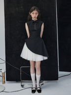 Woman wearing a black and white dress against a black background