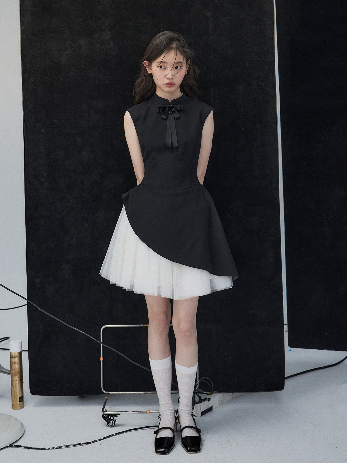 Woman wearing a black and white dress against a black background