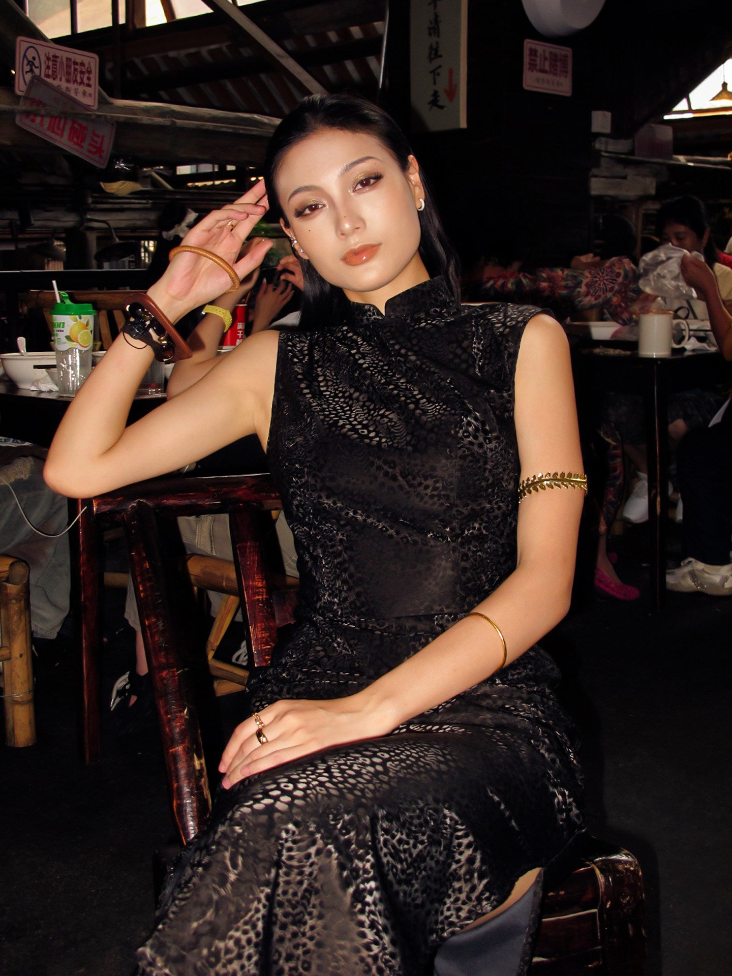 Woman in a black dress sitting in a restaurant setting