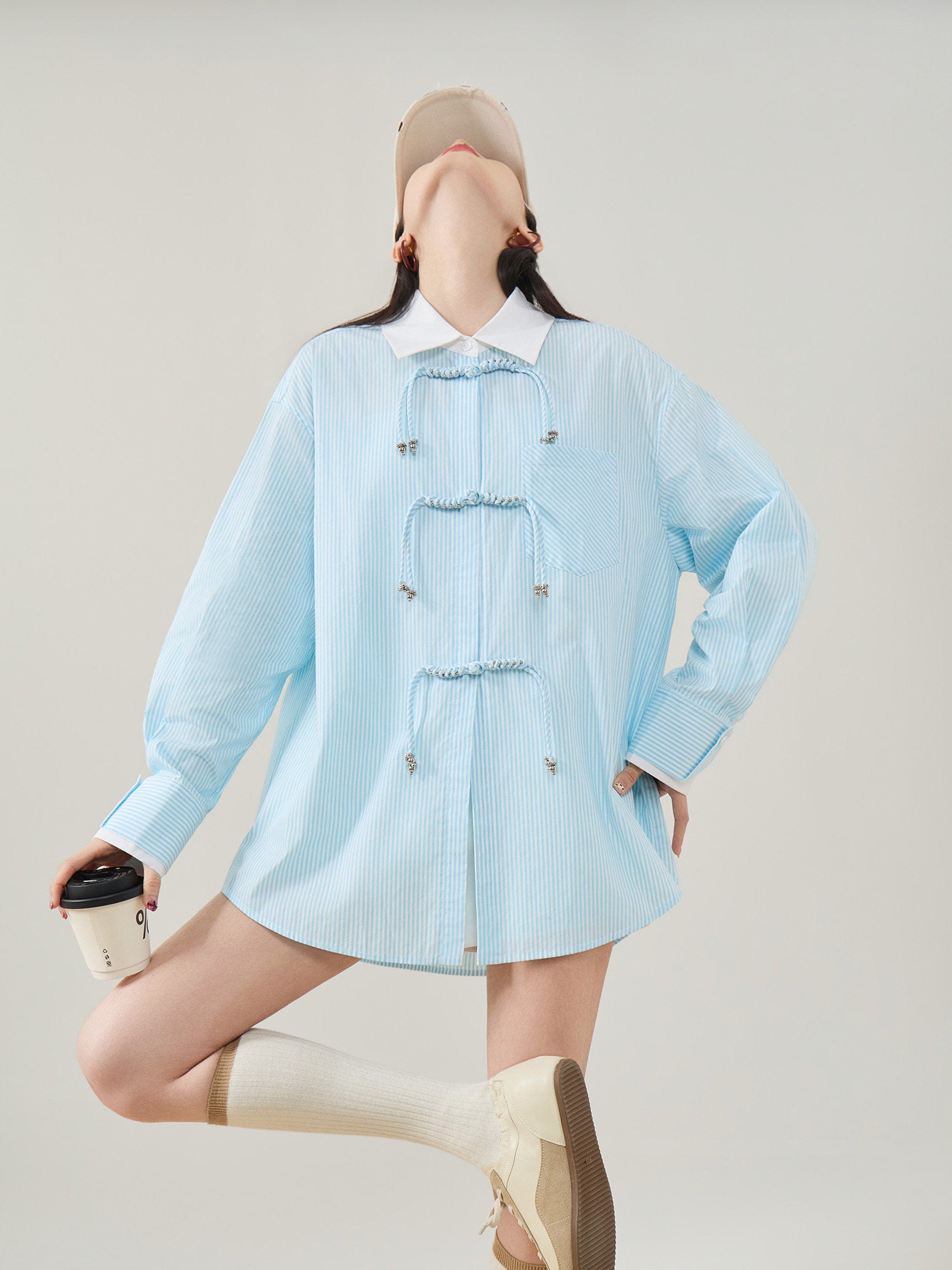 Person wearing a light blue checkered dress with a plain background