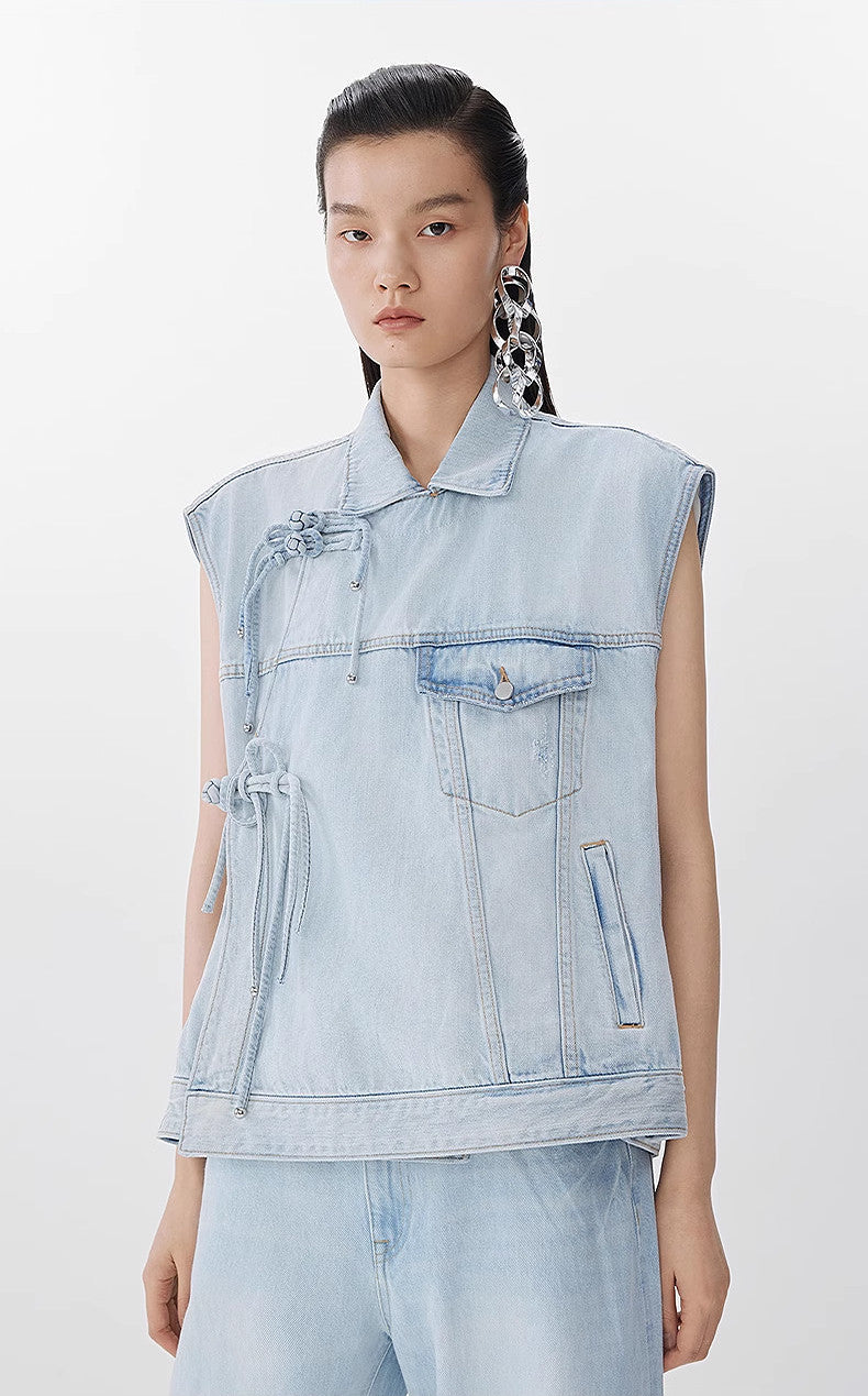Person wearing a light blue denim vest on a white background