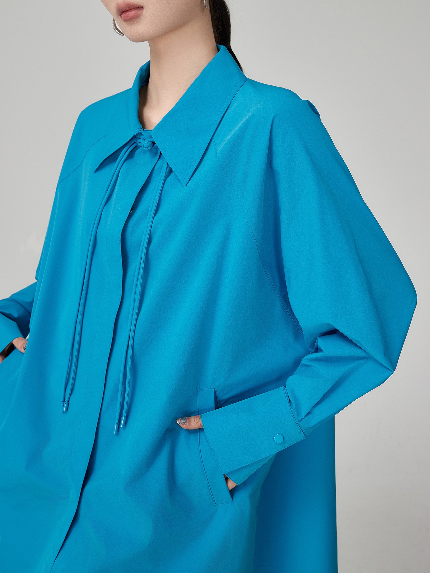 Blue shirt worn by a person on a gray background