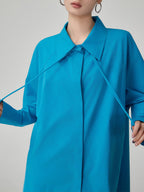 Blue coat worn by a person on a gray background