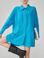 Blue dress worn by a person on a plain background