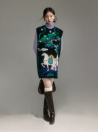 Model wearing a patterned vest with a horse design on a plain background