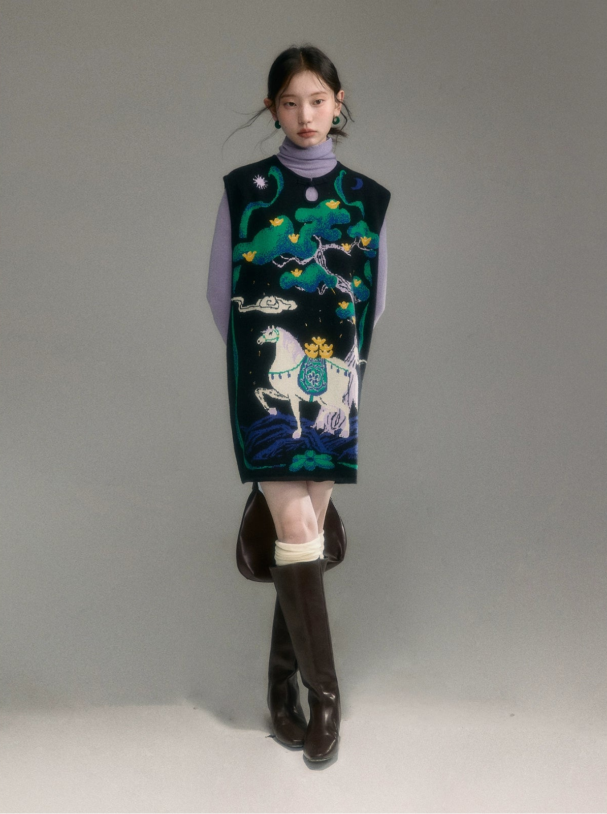 Model wearing a patterned vest with a horse design on a plain background