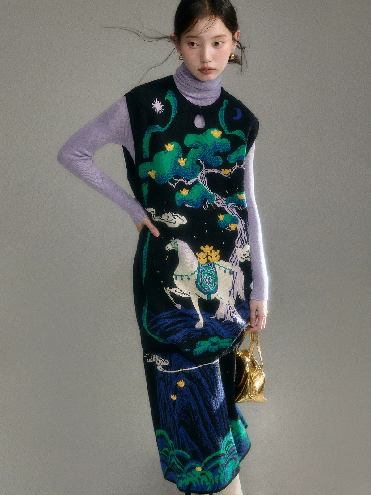 Woman wearing a long, patterned dress with a horse design against a plain background