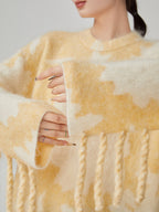 Close-up of a person wearing a yellow and white patterned sweater with braided details.
