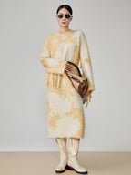 Woman wearing a yellow and white patterned outfit with a brown handbag on a plain background