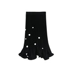 Black pleated skirt with white polka dots on a white background