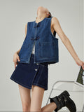 Woman wearing a denim vest and skirt set on a plain background