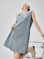 Woman wearing a light blue denim dress on a white background