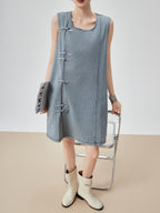 Person wearing a denim dress with a plain background