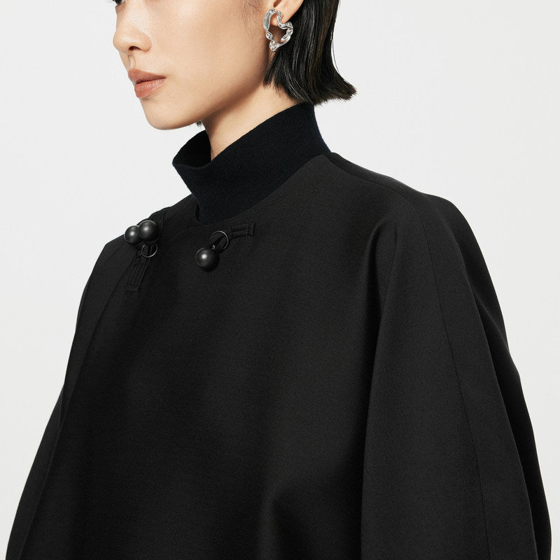 Black coat with button details on a plain background