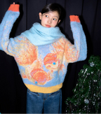 Person wearing a colorful sweater with a fish pattern against a dark background