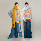 Two people wearing colorful sweaters and scarves on a plain background