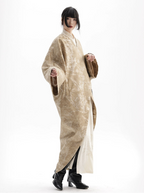 Person wearing a long, light-colored dress with a white background