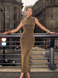Woman in a gold dress standing on a city street with buildings in the background