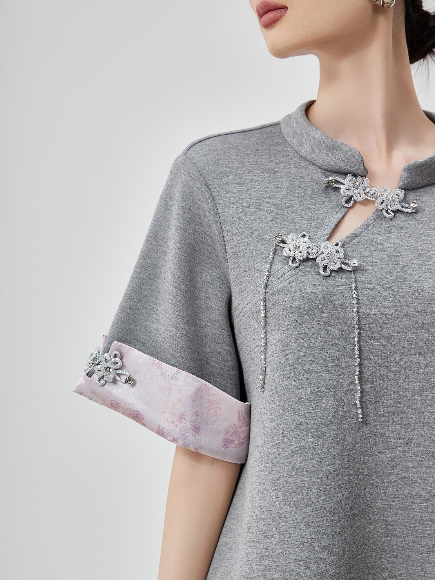 Gray dress with floral embellishments on a plain background