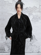 Person wearing a black textured coat against a light gray background