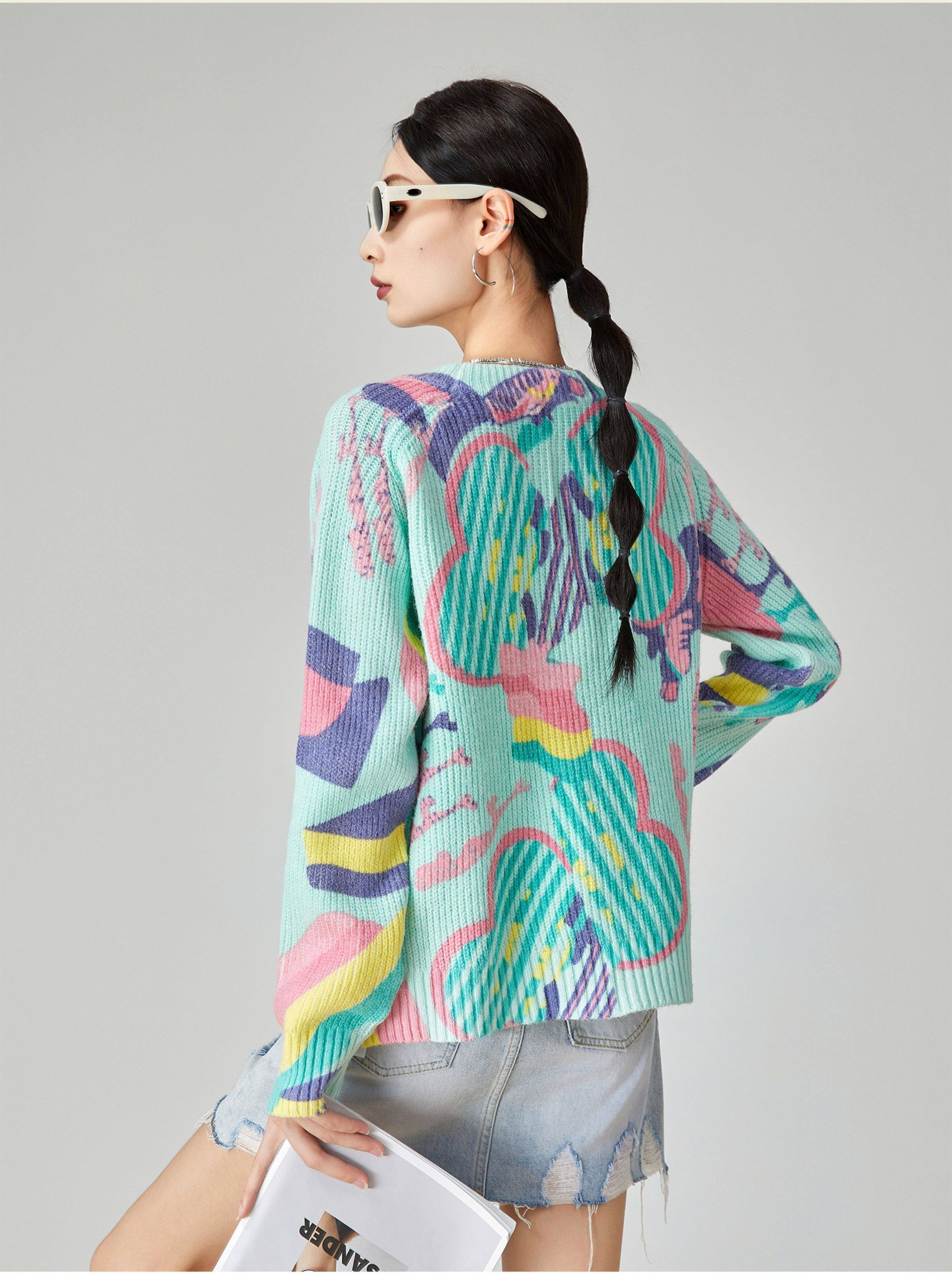 Woman wearing a colorful patterned sweater on a plain background