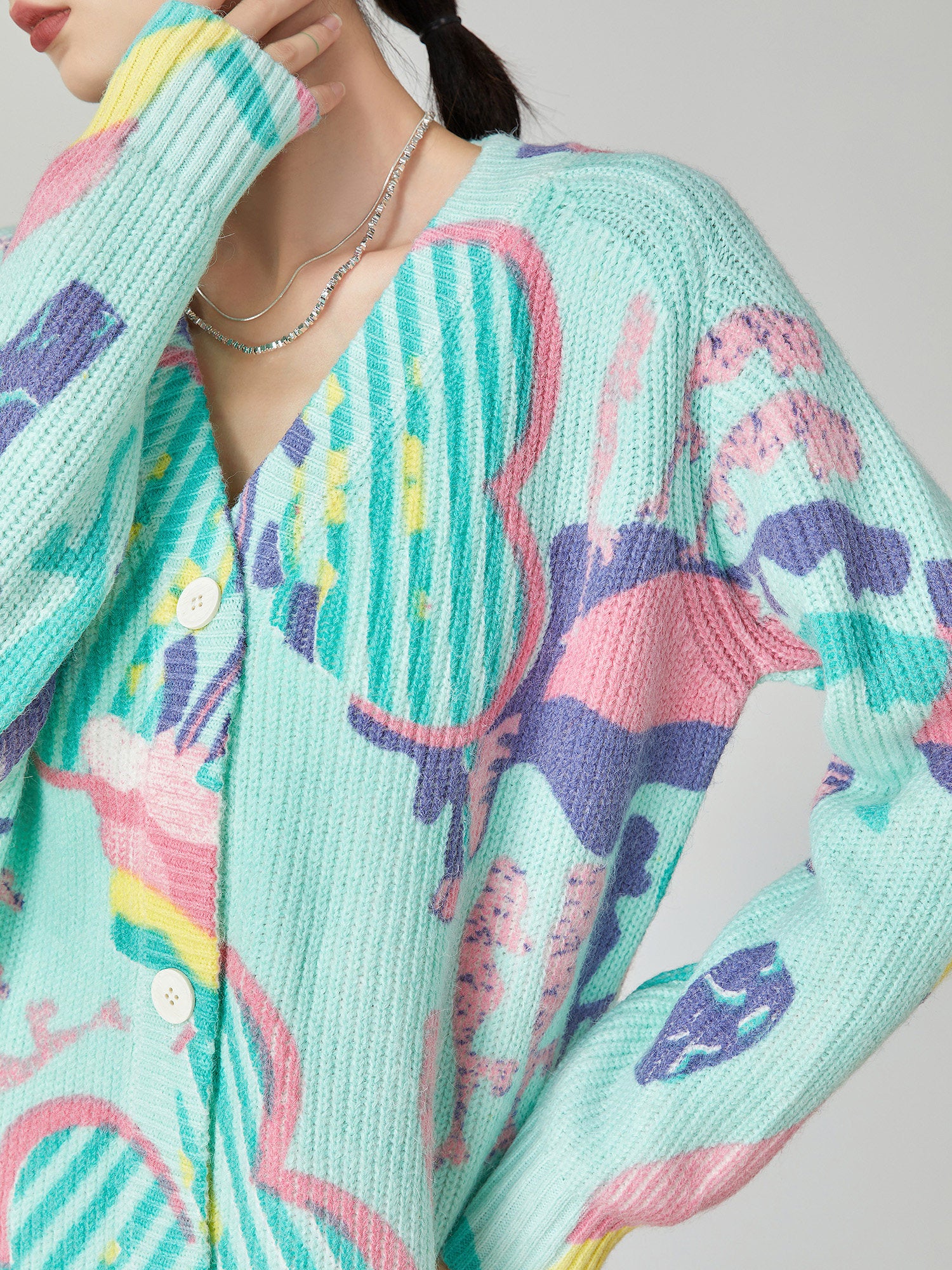 Colorful knitted cardigan with abstract patterns on a neutral background