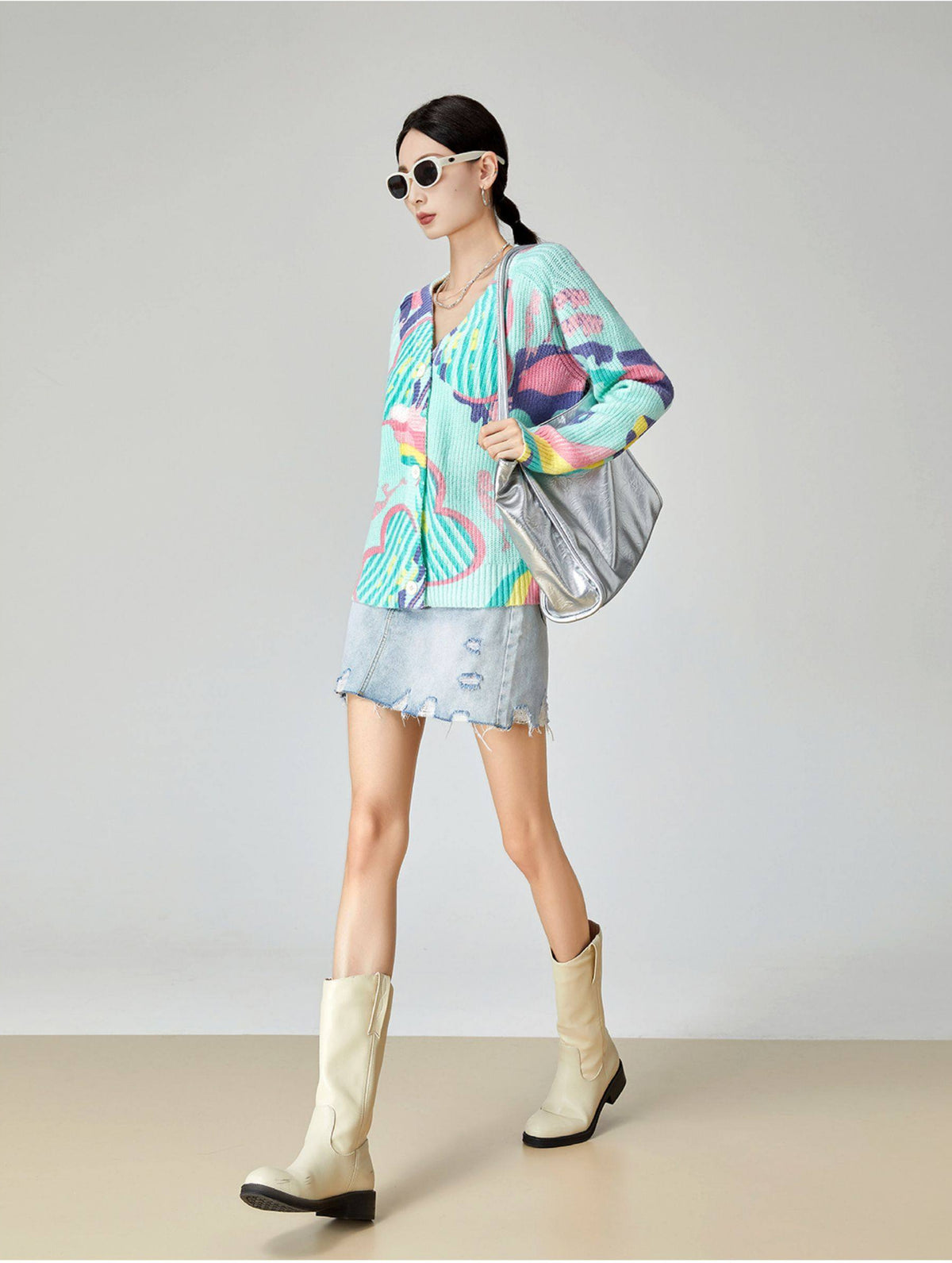 Woman wearing a colorful outfit with a jacket and skirt, standing against a plain background.