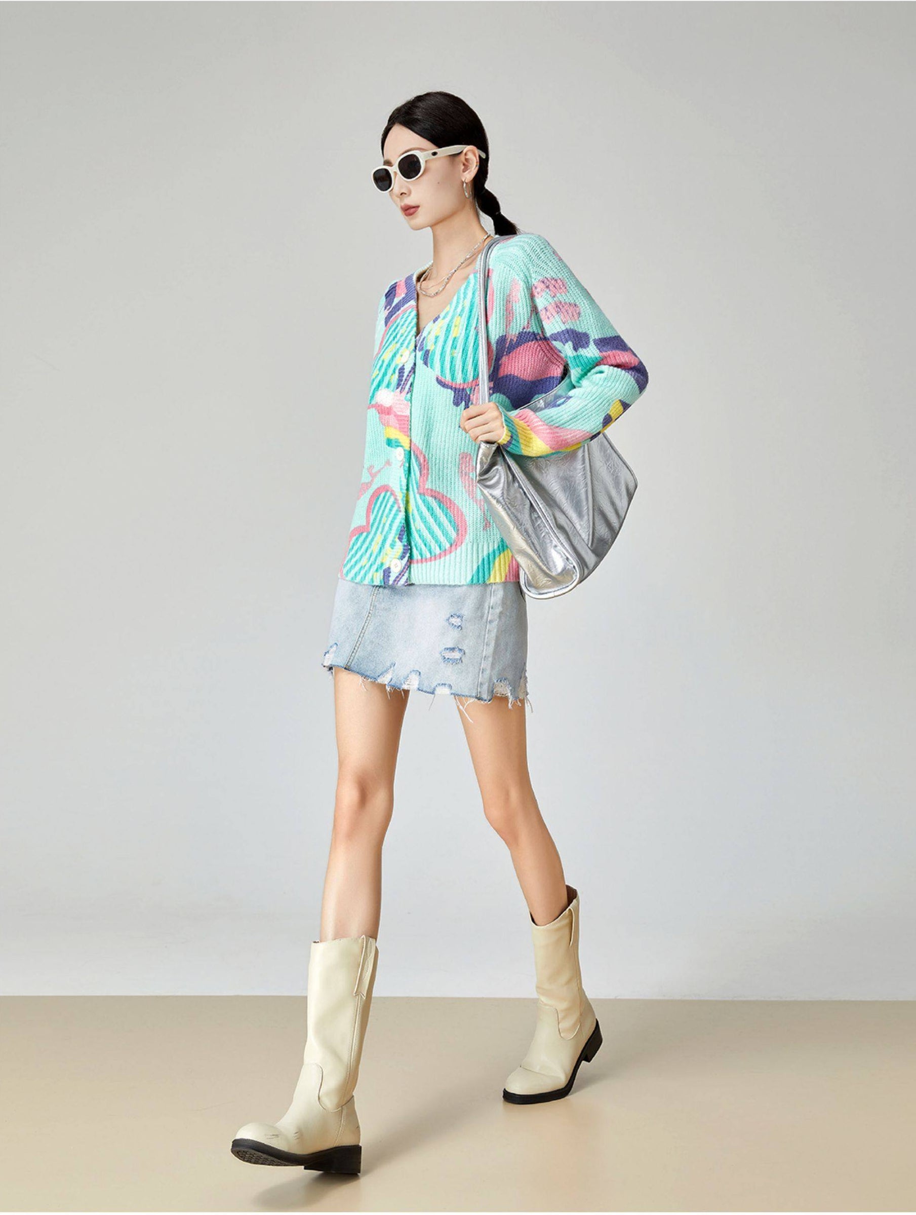 Woman wearing a colorful outfit with a jacket and skirt, standing against a plain background.