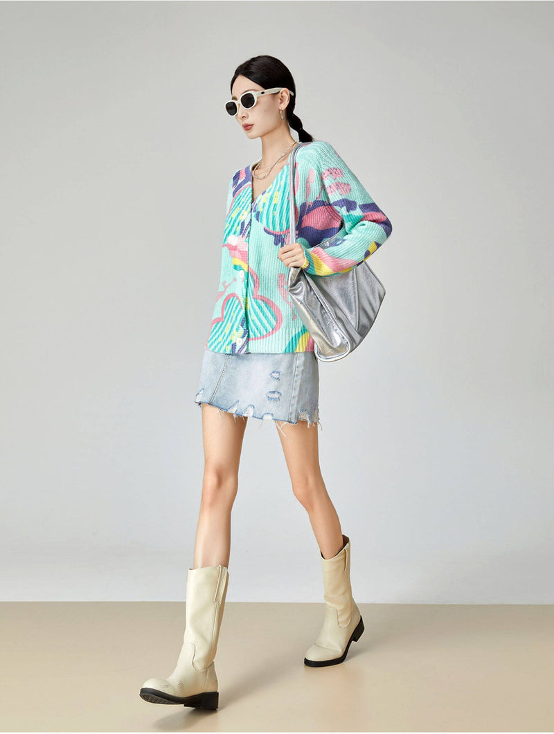 Woman wearing a colorful outfit with a jacket and skirt, standing against a plain background.