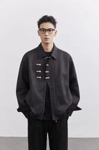 Person wearing a dark jacket with button details on a white background