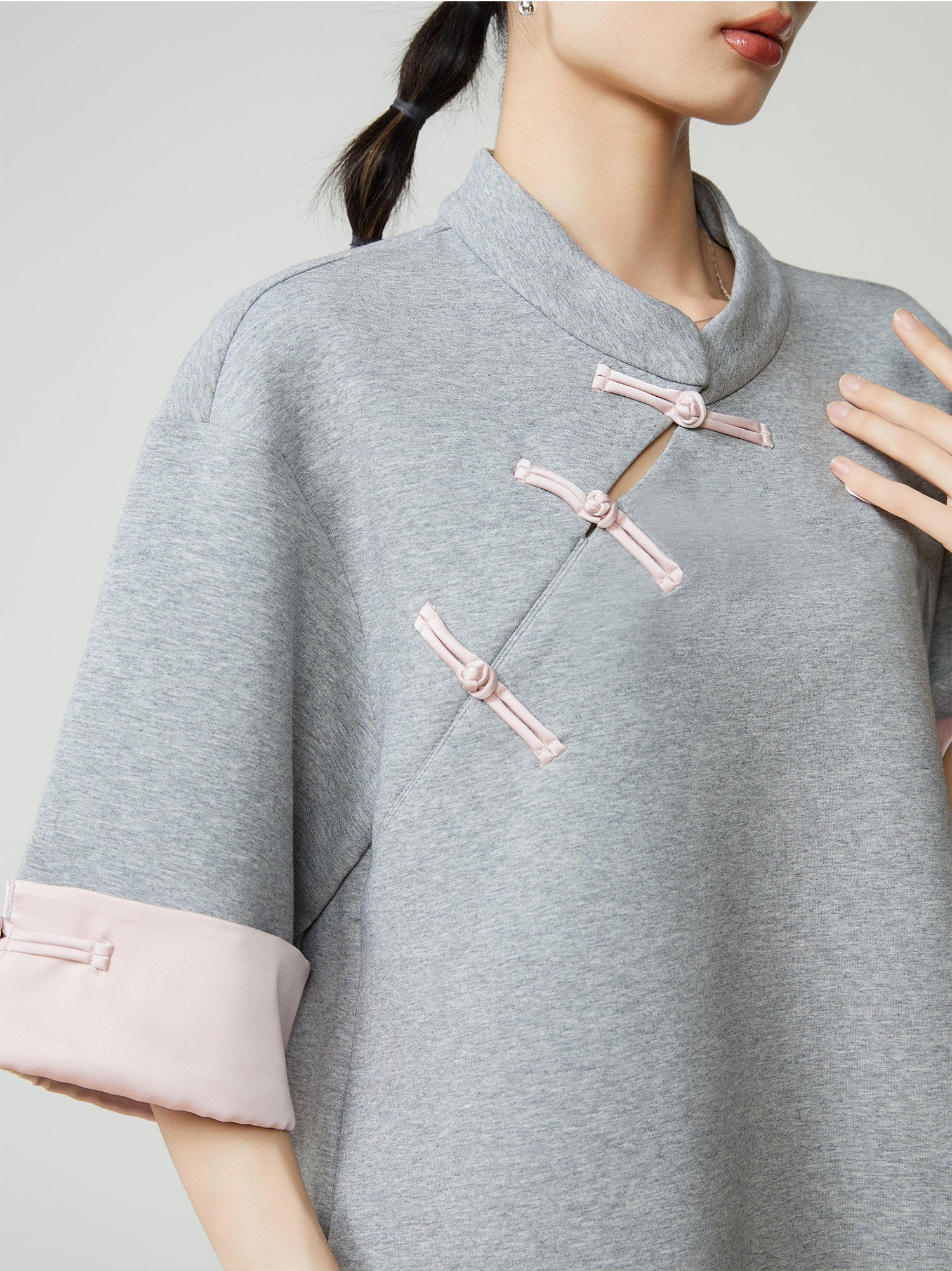 Grey traditional outfit with pink accents on a plain background