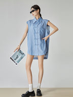 Woman wearing a blue striped sleeveless dress against a plain background