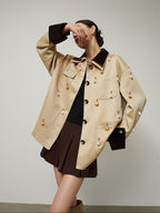 Woman wearing a beige trench coat with gold buttons on a plain background