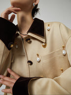 Close-up of a beige coat with decorative buttons on a neutral background