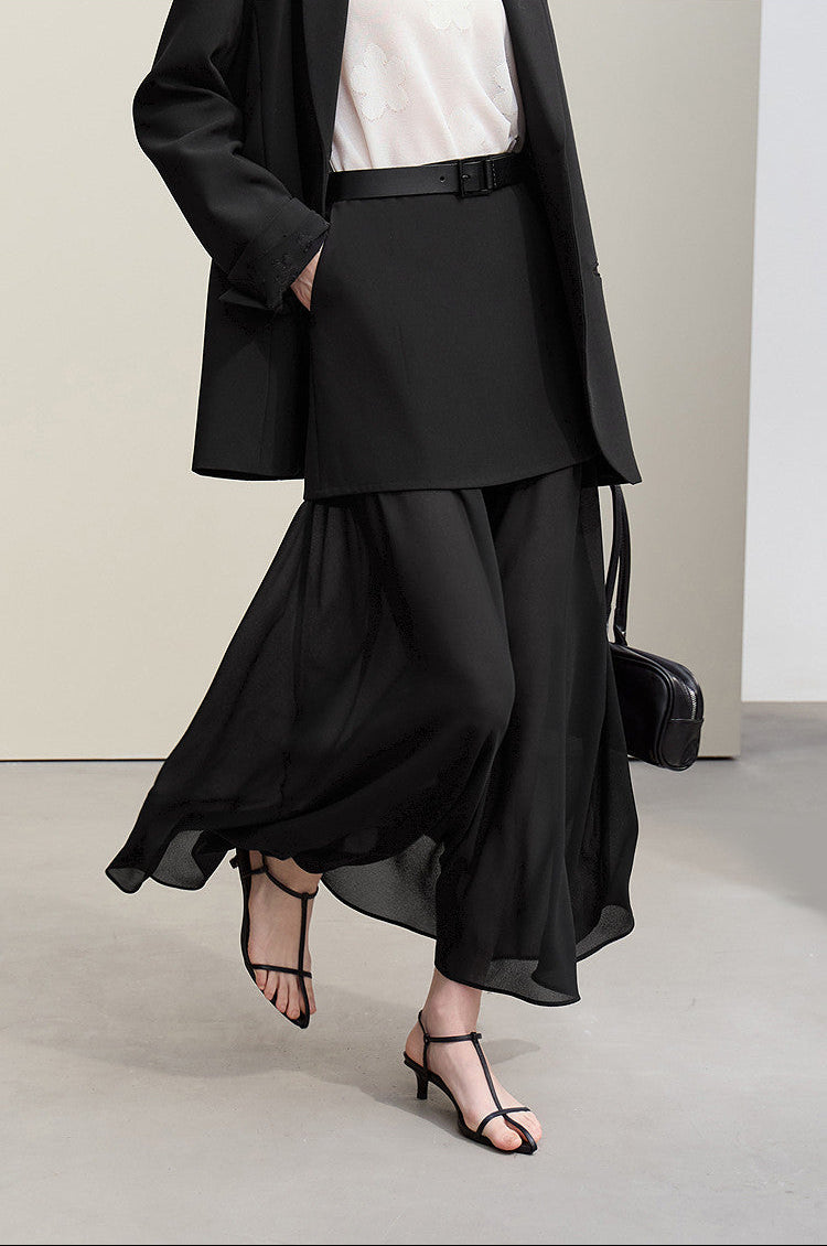 Person wearing a black outfit with a white shirt, standing against a neutral background with 'Amii' branding.