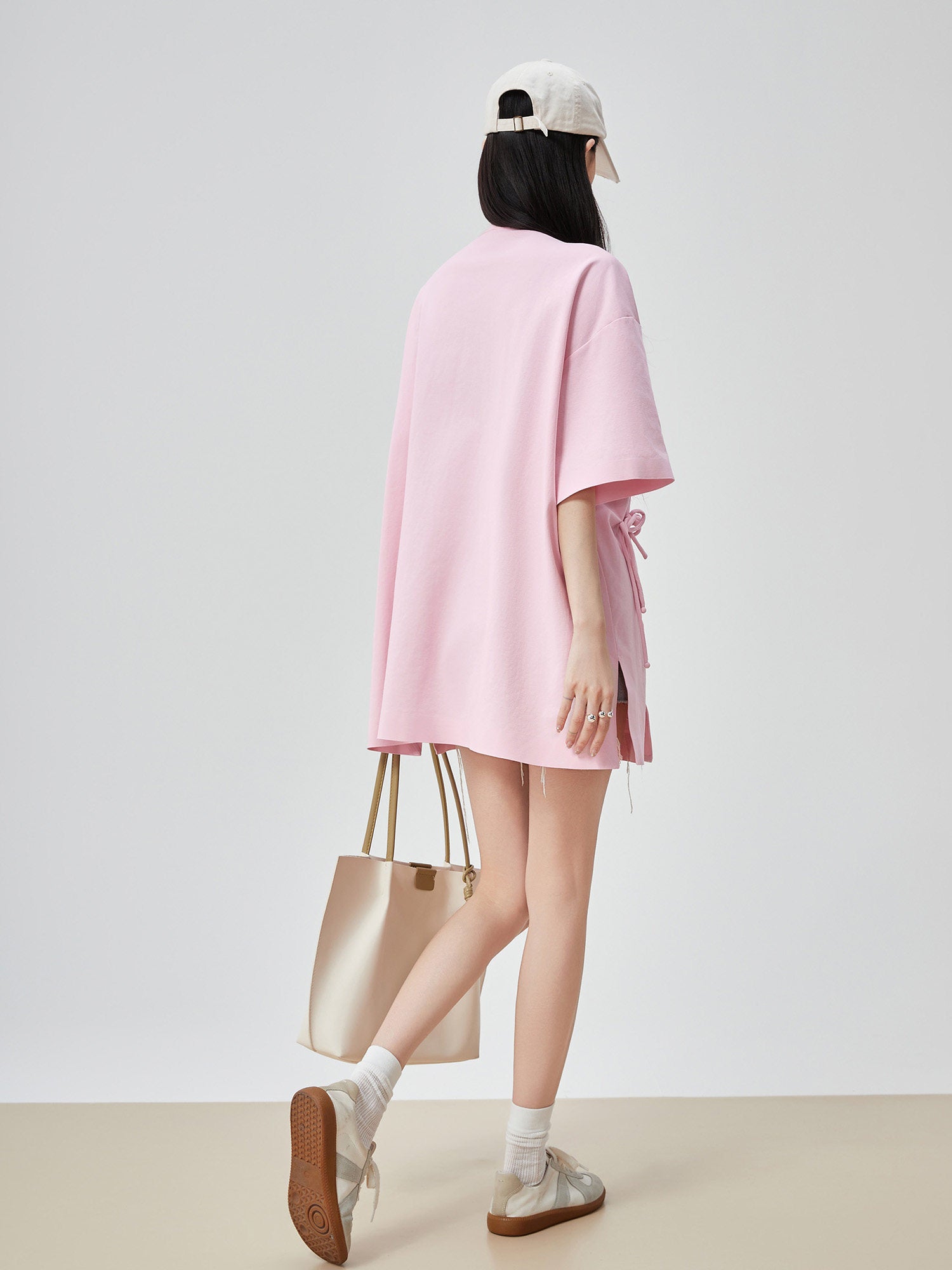 Person wearing a pink dress with a white background