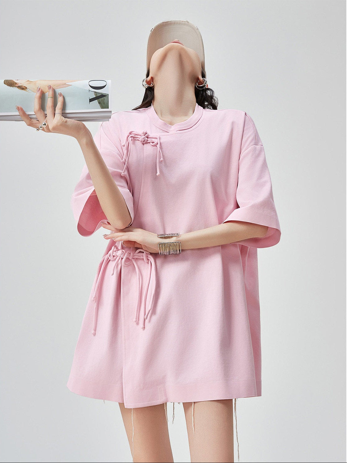 Person wearing a pink dress with a plain background