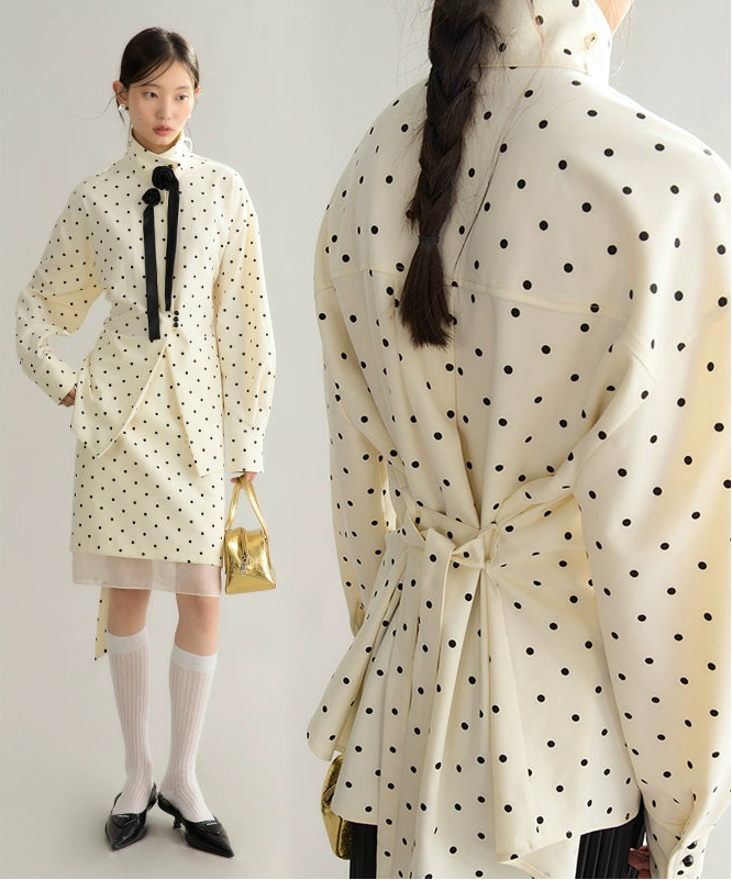 Woman wearing a polka dot raincoat with a plain background