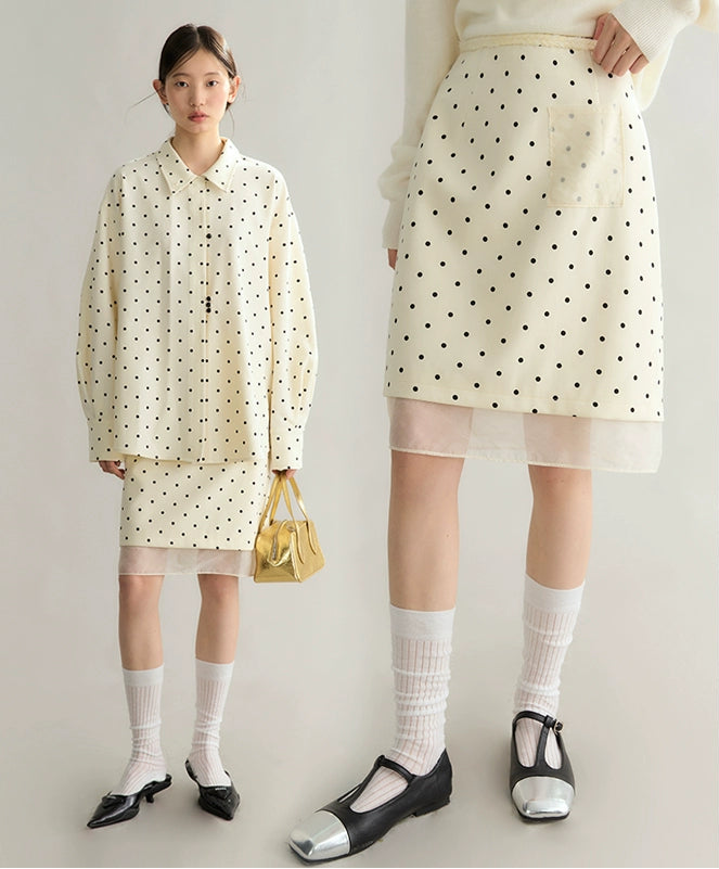 Two people wearing matching polka dot outfits with a plain background