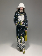 Person wearing a patterned outfit with a unicorn design on a plain background