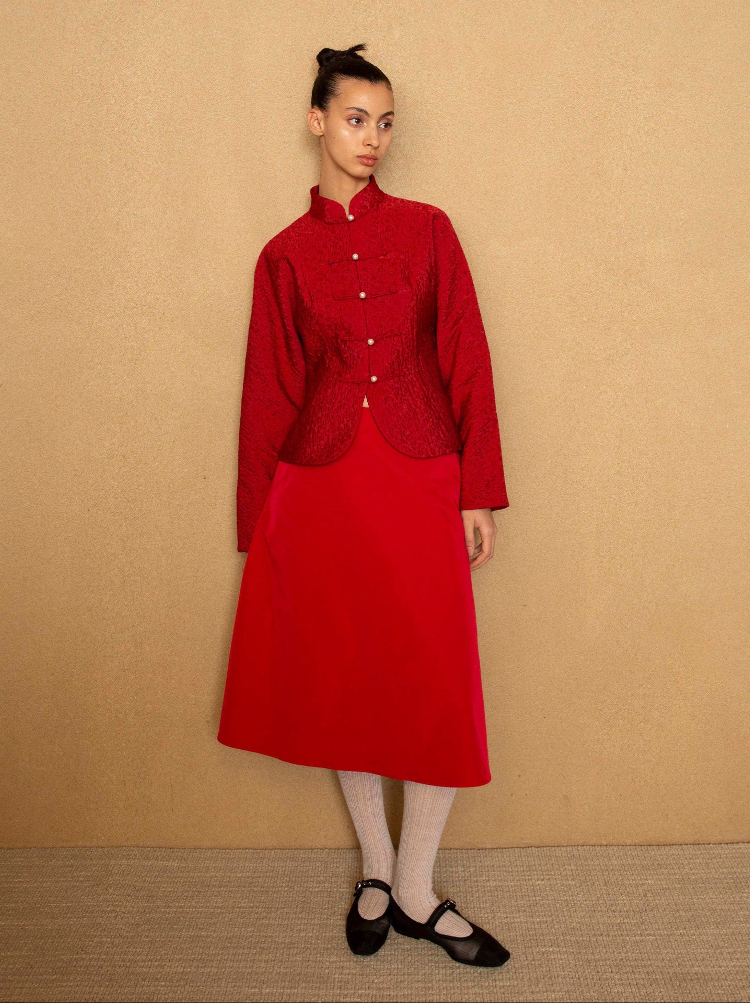 Person wearing a red outfit against a beige background