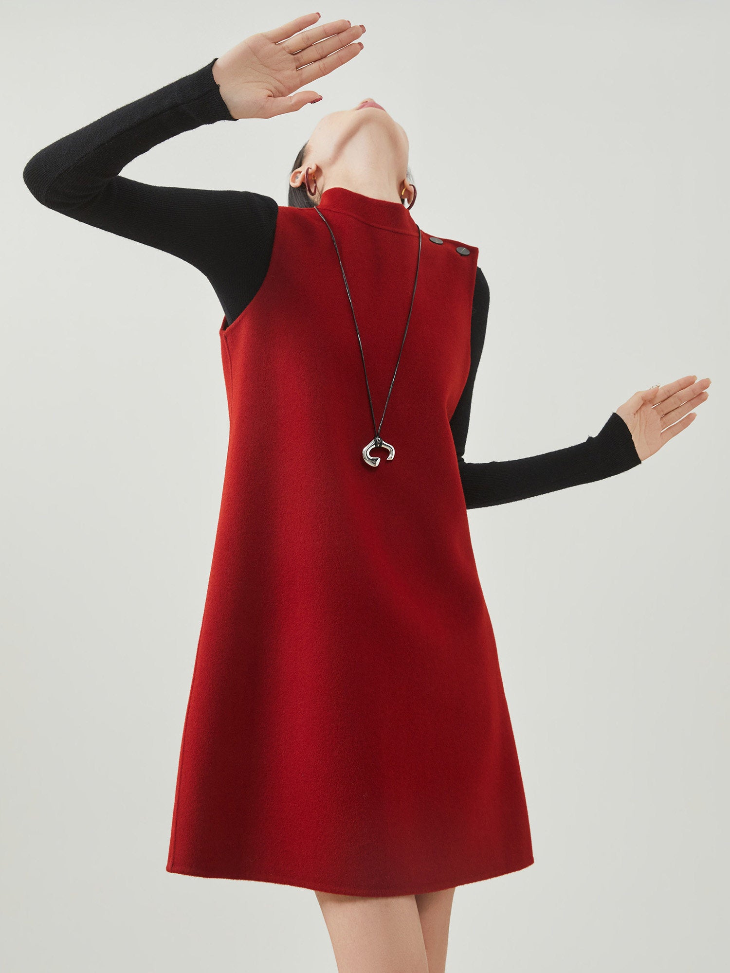 Red dress with black sleeves on a plain background