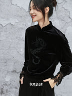 Woman wearing a black velvet outfit with lace sleeves against a gray textured background