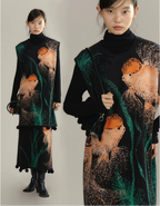 Woman wearing a black dress with fish pattern holding a matching handbag.