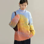 Person wearing a colorful sweater with a gradient effect, holding a brown bag.