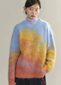Person wearing a colorful sweater with a gradient from blue to yellow to pink.