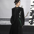 Woman wearing a black coat with floral embroidery against a minimalistic background